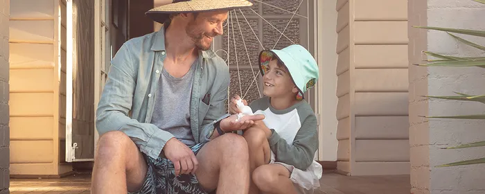 Father and son on porch being sun smart