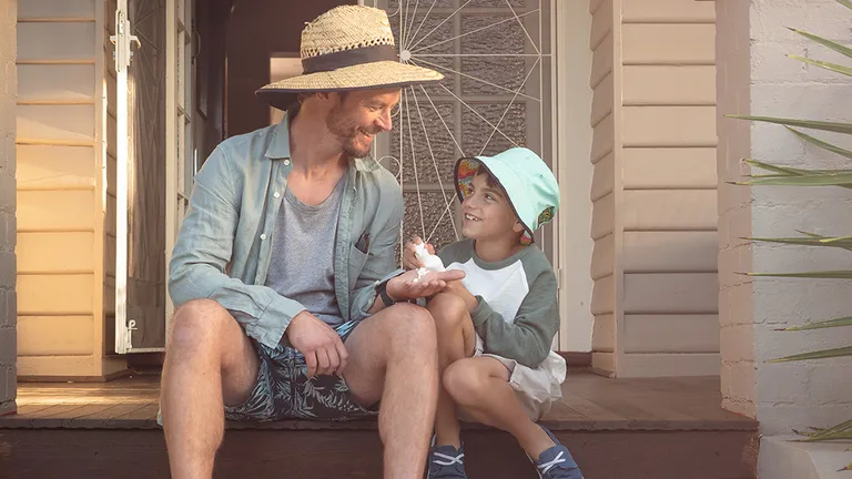 Father and son on porch being sun smart