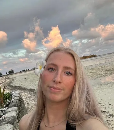 Selfie of a woman on the beach smiling.