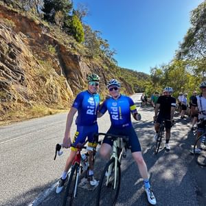 Two people on their bikes riding through the hills.