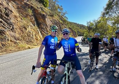 Two people on their bikes riding through the hills.