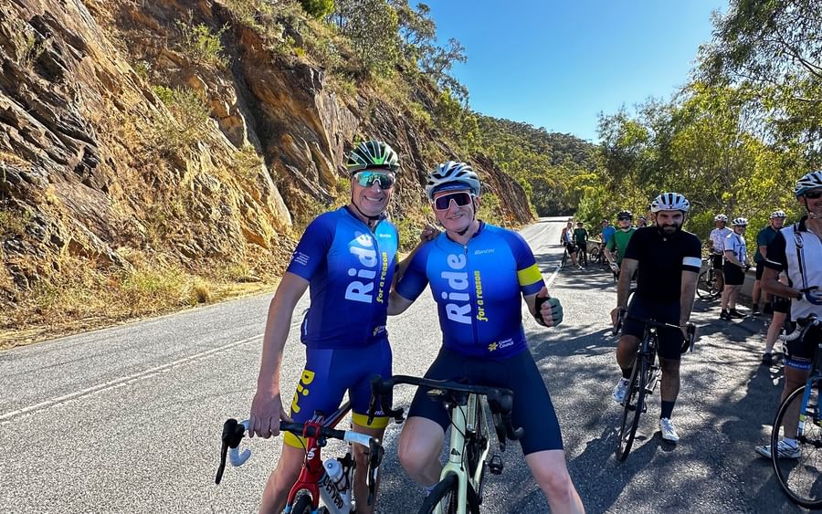 Two people on their bikes riding through the hills.