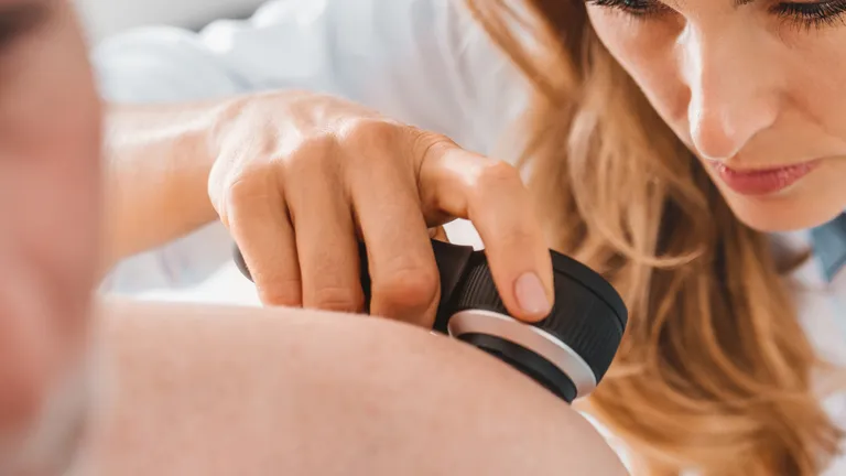 Medical professional using a handheld ultrasound probe on a patient’s shoulder.