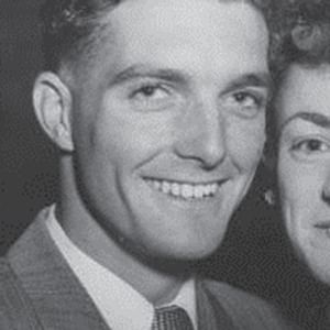Black-and-white portrait of a smiling couple posing closely, one on the left and the other on the right.