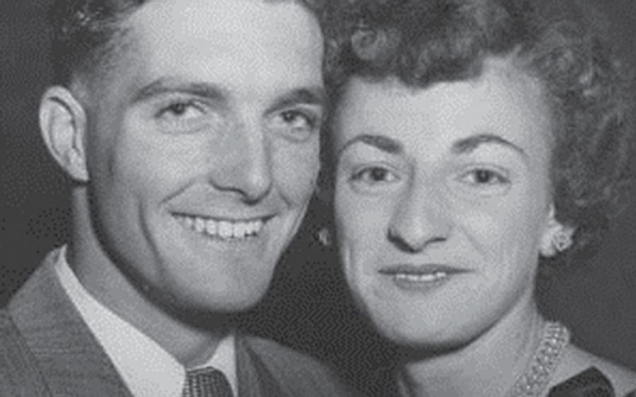 Black-and-white portrait of a smiling couple posing closely, one on the left and the other on the right.