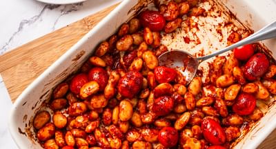 Roasted cherry tomatoes and potatoes in a white baking dish; plate of toast with tomatoes and feta.