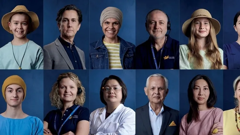 Twelve diverse professionals posed in two rows against a blue backdrop.