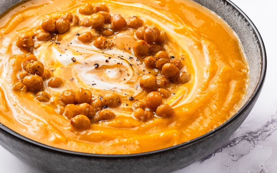 A bowl of pumpkin and chickpea soup with crispy croutons