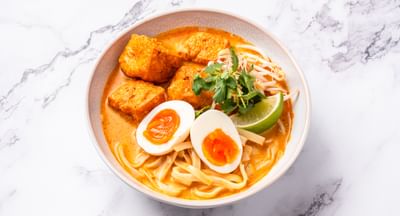 A bowl of tofu laksa with soft-boiled eggs