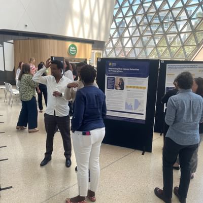 A group of people in the foyer of the Research Symposium.