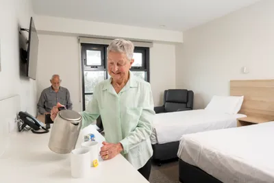 A woman makes a cup of tea for her and her partner in a room at the Greenhill Lodge