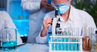 A group of young scientists are conducting experiments in the lab using a microscope (iStock).