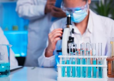 A group of young scientists are conducting experiments in the lab using a microscope (iStock).