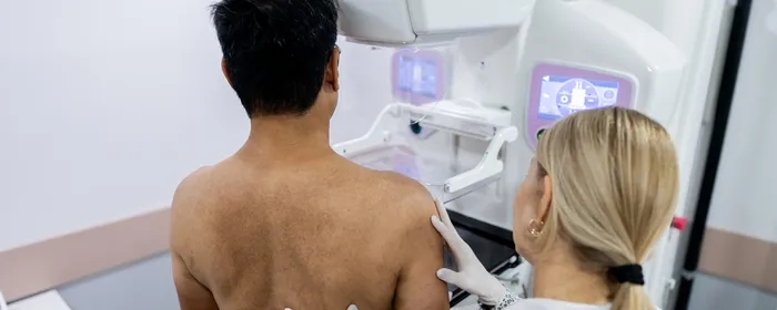 Doctor performing mammography examination testing for breast cancer on male patient in clinic